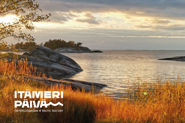 Merenlahti myöhäiskesällä auringon laskiessa. Itämeripäivän logo alakulmassa.